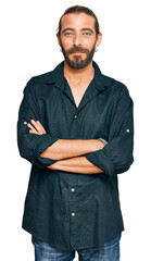 Attractive man with long hair and beard wearing casual clothes thinking attitude and sober expression looking self confident