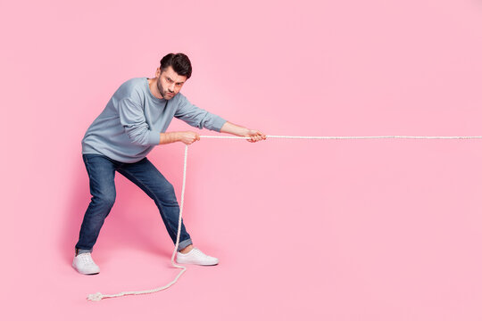 Full length photo of motivated guy ready pull string compete tug war isolated on pastel color background