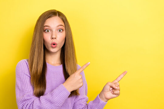 Portrait photo of teenager lady wear knitted sweater pouted lips unexpected reaction fingers directing empty space promo shock isolated on yellow color background