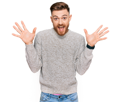 Young redhead man wearing casual winter sweater celebrating crazy and amazed for success with arms raised and open eyes screaming excited. winner concept