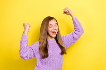 Photo of little cute schoolgirl teenager wear knitted purple sweatshirt fists up hooray success good marks college isolated on yellow color background