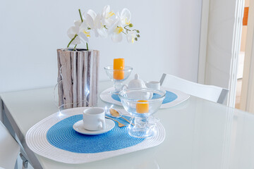 arranged breakfast table with plates and glasses