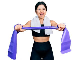 Young brunette woman with blue eyes training arm resistance with elastic arm bands smiling and laughing hard out loud because funny crazy joke.