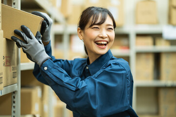 倉庫内作業をする日本人女性 - obrazy, fototapety, plakaty