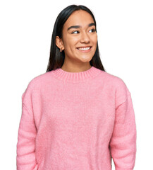 Young asian woman wearing casual winter sweater looking away to side with smile on face, natural...
