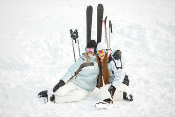 Girls posing against backdrop of mountains in ski gear.