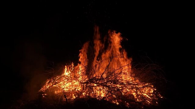 A pile of burning branches at night. Bonfire on a dark background.