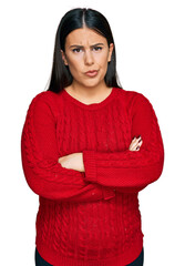 Beautiful brunette woman wearing casual sweater skeptic and nervous, disapproving expression on face with crossed arms. negative person.