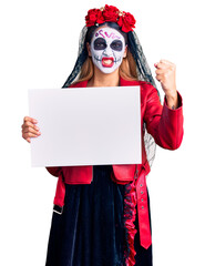 Woman wearing day of the dead costume holding blank empty banner annoyed and frustrated shouting with anger, yelling crazy with anger and hand raised