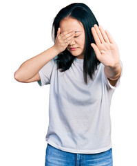 Young chinese woman wearing casual white t shirt covering eyes with hands and doing stop gesture with sad and fear expression. embarrassed and negative concept.