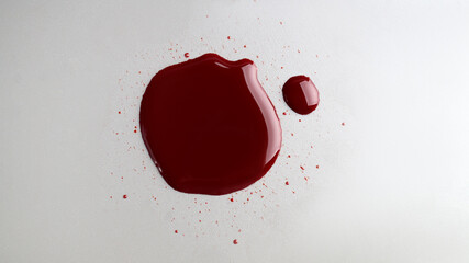 Stain of blood on light grey background, top view