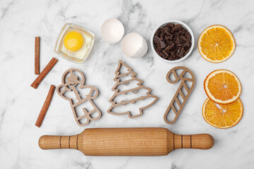 Flat lay composition with cookie cutters and ingredients on white marble table