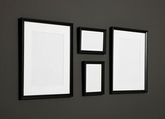 Empty frames on black wall. Mockup for design