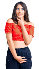 Fototapeta premium Brunette teenager girl wearing casual clothes with hand on chin thinking about question, pensive expression. smiling with thoughtful face. doubt concept.