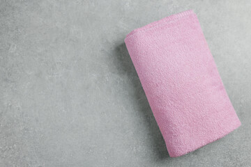 Soft folded towel on gray background, top view. Space for text