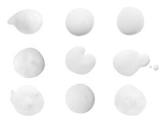 Set with drops of fluffy soap foam on white background, top view