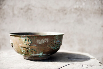 Chinese bronze bowl with calligraphy and a dragon sculpted around its outer circumference. . 