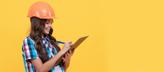making notes. child in helmet read project. construction documents. signing a contract. Child builder in helmet horizontal poster design. Banner header, copy space.