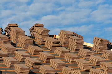 Piles of concrete roof tiles prior to installation on top of home under construction