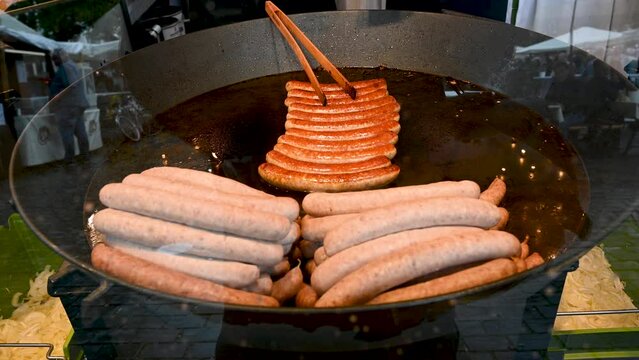 Traditional Sausages on the grill. Cooking Delicious Sausage on Christmas market. Grilling tasty sausages on barbecue.
