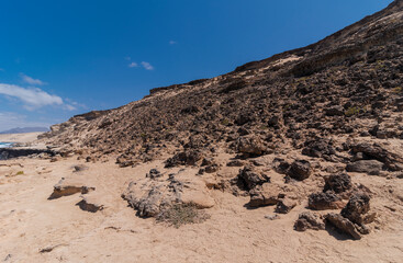 Dark desert elevation with white colored coastline hiking trail, Fuerteventura, Canary Islands