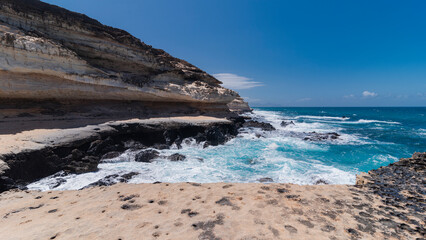 Untamed Atlantic ocean waves with very steep cliff made of light to dark colored rocks, Canary Islands