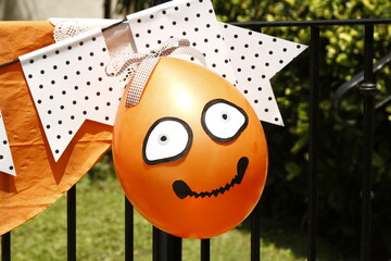 Orange party balloon with DIY smiling cartoon faces