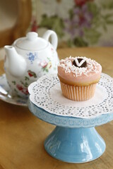 Closeup of a cupcake on a pastel colored cupcake stand