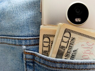 Cash money dollar and smartphone in jeans back pocket, concept of money making with online...