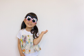 サングラスをかけて指差しをする女の子