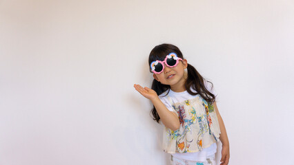 サングラスをかけて指差しをする女の子