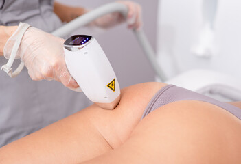 Professional beautician removes hair on beautiful female buttocks using a laser. hair removal on...