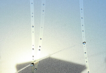 車のフロントガラスの水滴と朝日