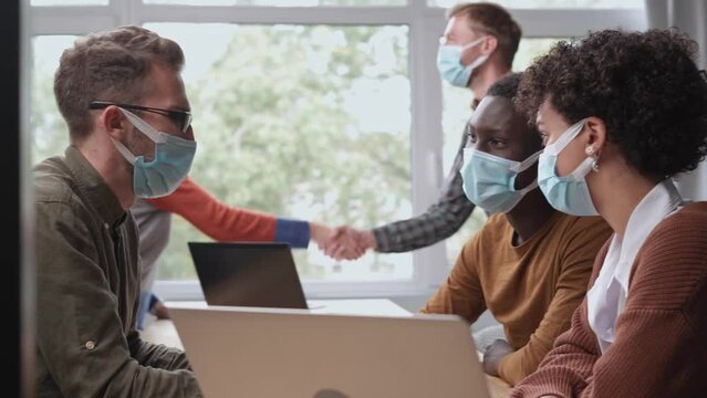business people in protective masks working in a modern coworking center.
