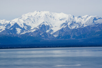 Snowy mountains at waters edge in alaska 