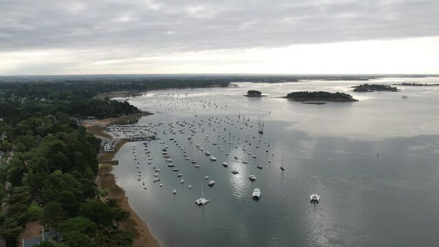 aerial drone hyperlapse at sunrise over a water mirror, with cloud movement, with boat's.
