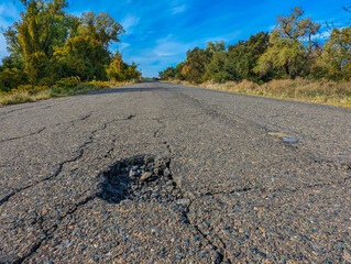 Large pothole in road in forest