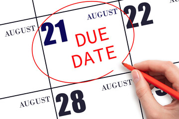 Hand writing text DUE DATE on calendar date August 21 and circling it. Payment due date