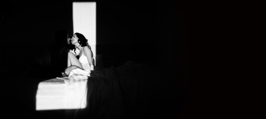 Young passionate couple kissing making love in bed. Black and white photo