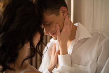 Close-up of a kissing couple face to face. Morning men and women kiss at the window.