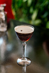 elegante espresso martini cóctel bebida espuma grano de café preparado en la barra al aire libre con colador, receta  