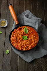 Meat tomato sauce in pan bolognese on marble surface food top view on wooden surface