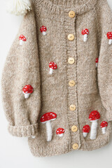 Baby knitted clothes. Handmade knitted sweater with fly agaric mushrooms. Jacket with embroidery