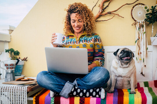 People and dog best friends forever together. One happy woman smile and use laptop sitting near her lovely friend companion dog pug. Animal and business lifestyle moment. Modern leisure activity - Powered by Adobe