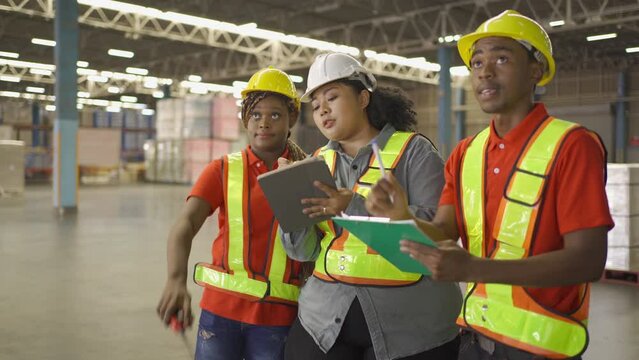 Teamwork of black workers and fat woman working in large warehouse retail store industry. Rack of stock storage. Interior of cargo in ecommerce and logistic. Depot. People lifestyle. Shipment service.