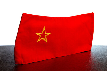 Red Soviet pioneer cap with a yellow star. Close-up, selective focus.