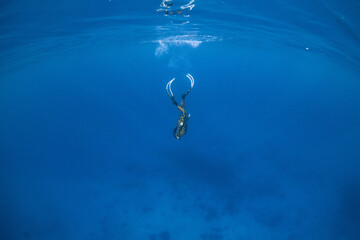 Women having fun underwater snorkeling in shallow clear waters with sunrays in the ocean
