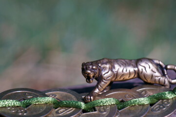 Tiger figurine with Chinese coins. A religious symbol. Feng shui figurines.