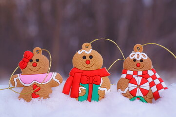 Three gingerbread decorated men on a background of snow. Christmas decorations.