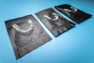 corrective aligners for the beauty of teeth lie on a black package. special storage bags. dentistry and health care